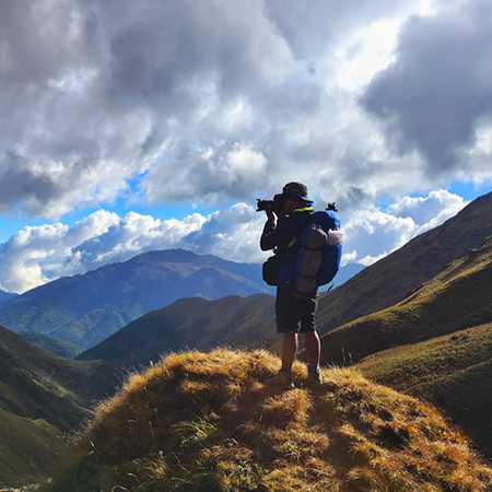 gallary man on mountain with camera